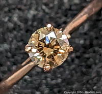 Close-up of brown diamond solitaire ring set in rose gold prong setting on tapered band