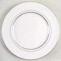 Top view of one bread plate showing the white surface with a delicate blue floral garland pattern ring near the rim and silver edging.