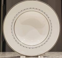 Close-up of a single salad plate showing the ornate Tiara pattern with gold trim on white fine china.