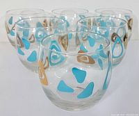 Front view of 6 roly poly glasses showing turquoise and gold amoeba boomerang pattern