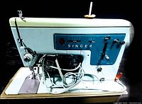 Light blue and white Singer Model 347 vintage sewing machine on table, showing front and side controls, needle plate, and power cord.