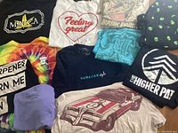 Overview of 11 XL size T-shirts showing various graphic prints including logos and artistic designs.