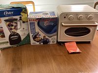 Oster blender, George Foreman grill box, and electric toaster oven with air fryer on table