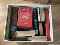 Top view photo of 17 vintage hardcover books showing binding, colors and sizes.