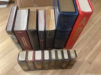 Shows the variety of faux books in the lot standing upright on a wooden floor.