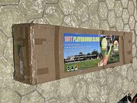 Long rectangular box with label showing details of 10ft Playground Slide including sturdy steel frame, smooth powder-coated steel powder, ages 3-10, includes easy connect features.