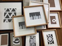 Set of various wood grain, black, white, and metal picture frames in 8x6, 9x11, 10.5x9, 13x13, and 16x20 inch sizes.