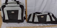 Front and top view of Bella Russo small silver and black bag and travel overnight suitcase on white background with ruler for scale.