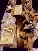 Two new full body safety harnesses with multiple straps and buckles, one still sealed in plastic packaging.