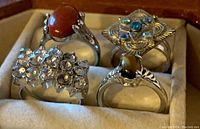 Four ladies rings displayed in a box, showing stones and crystal details