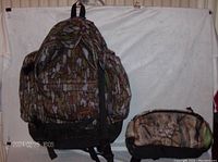 Camouflage backpack and fanny pack displayed against a white background, showing their sizes and overall condition.