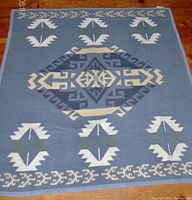 Blue and white side of the Turkish Nemcor throw blanket with central blue and cream geometric Aztec medallion and bordered design.