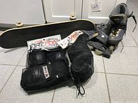 Full view of roller blades, skateboard, and 2 sets of protective gear