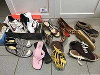 Top-down view of all footwear arranged on floor showing variety and condition