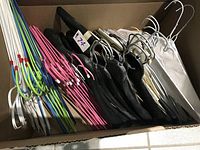 Image showing assorted hangers including pink metal, white wire, green and blue hangers, black velvet and white padded hangers in a box.