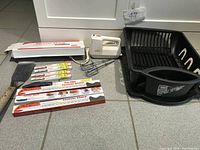 Photo showing drying dish rack, knives and hand mixer with beaters