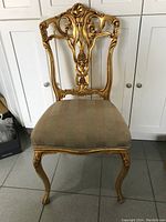 Front view of the gold wood carved parlor chair showing detailed upholstery and ornate backrest design