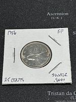 Front side of the 1956 Canadian 25 cents coin showing the caribou design and handwritten notes about silver content and condition.