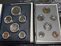 Photo showing two Canadian specimen sets side-by-side, each with 7 coins in capsules within original display cases, showing an overview of the lot.