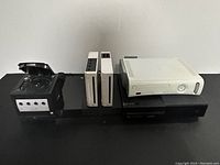 Six consoles displayed on a black shelf