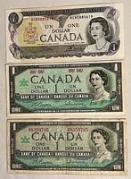 Front side of three Canadian one-dollar bills: one 1973 bill with black, yellow and purple colors and two 1967 Centennial Edition bills in green tones.