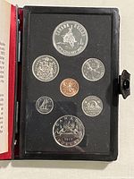 Obverse sides of the 7 coins in the set displayed in black holder, showing detailed engravings including Calgary Centennial commemorative coin and other coins.
