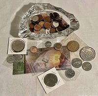 Crystal ashtray filled with assorted coins and tokens