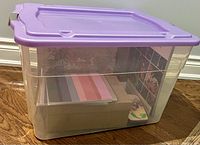 Closed plastic bin showing the purple lid and some visible contents inside.