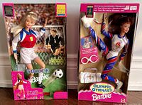 Front view of two boxed Barbies: FIFA Soccer Barbie and Olympic Gymnast Barbie side by side.
