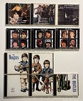 Front view of 9 Beatles related CD jewel cases showing front cover artwork including band members and titles