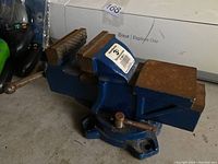 Photo of blue metal bench vise with swivel base and 3-inch jaws showing some surface rust and usage wear.