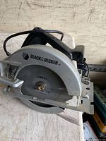 Photo of Black & Decker branded circular saw with visible 1800 watt specification, metal cutting blade, and corded power supply.