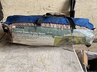 Polyester dome screen house tent in its carrying bag showing size, brand, and key features description.