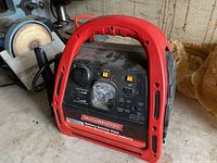 Red Motomaster battery booster pack with handle, USB ports, and LED light.