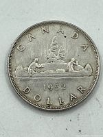 Photo of reverse side showing canoe with paddlers, trees, date 1952, and 'CANADA DOLLAR' text.