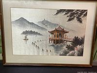 Full view of framed embroidered panel showing the lakeside pagoda and misty mountain landscape