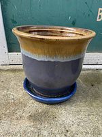 Side view of the jardiniere showing the glazed multicolour finish from mustard brown top rim to dark blue body and matching saucer underneath