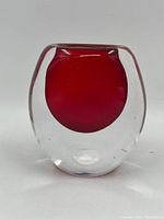 Front view of oval-shaped cranberry glass vase by Ernest Gordon, Åfors Sweden. Thick clear glass outer with embedded cranberry core.