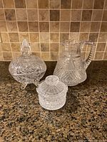 Overall view of the set showing all three crystal pieces on countertop with tile backsplash