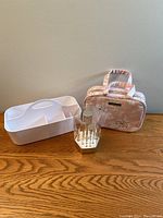 Wide view showing all items: white makeup storage caddy, pink floral cosmetic bag, makeup brush set in clear holder