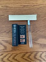 Photo showing the Stila eyeliner box along with Kat Von D mascara box and a Chloe Rose Eau de Toilette spray bottle on a wood surface.