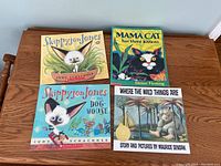 Four children's books displayed on a wooden table: Skippyjon Jones, Skippyjon Jones in the Doghouse, Mama Cat has three kittens, and Where the Wild Things Are.