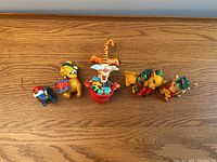 Photo showing six assorted children's Christmas ornaments featuring Winnie the Pooh characters including Eeyore, Winnie the Pooh with drum, Tigger, Tigger in gift container, and a reindeer with wreath.