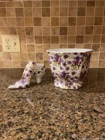 Front view of matching octagon plant pot and decorative high-heeled shoe, showing floral pattern and shape