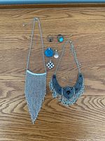 Full lot layout showing 2 necklaces, 3 pendants and 3 rings on wooden surface