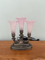 Front view of the lily accent lamp showing three pink glass shades and bronze base.