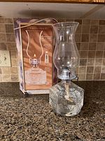 Oil lamp on countertop with its original box behind it, showing the lamp and packaging details