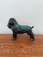 Side view of the Blue Mountain Pottery Cocker Spaniel ceramic sculpture showing overall form and glossy glaze finish in shades of green and brown.