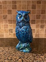 Front view of blue ceramic owl figurine showing intricate feather details and glossy glaze.