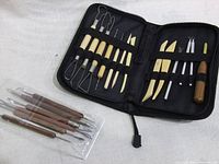 Full view of the open black zippered case displaying the full set of 15 sculpting tools arranged in elastic bands.